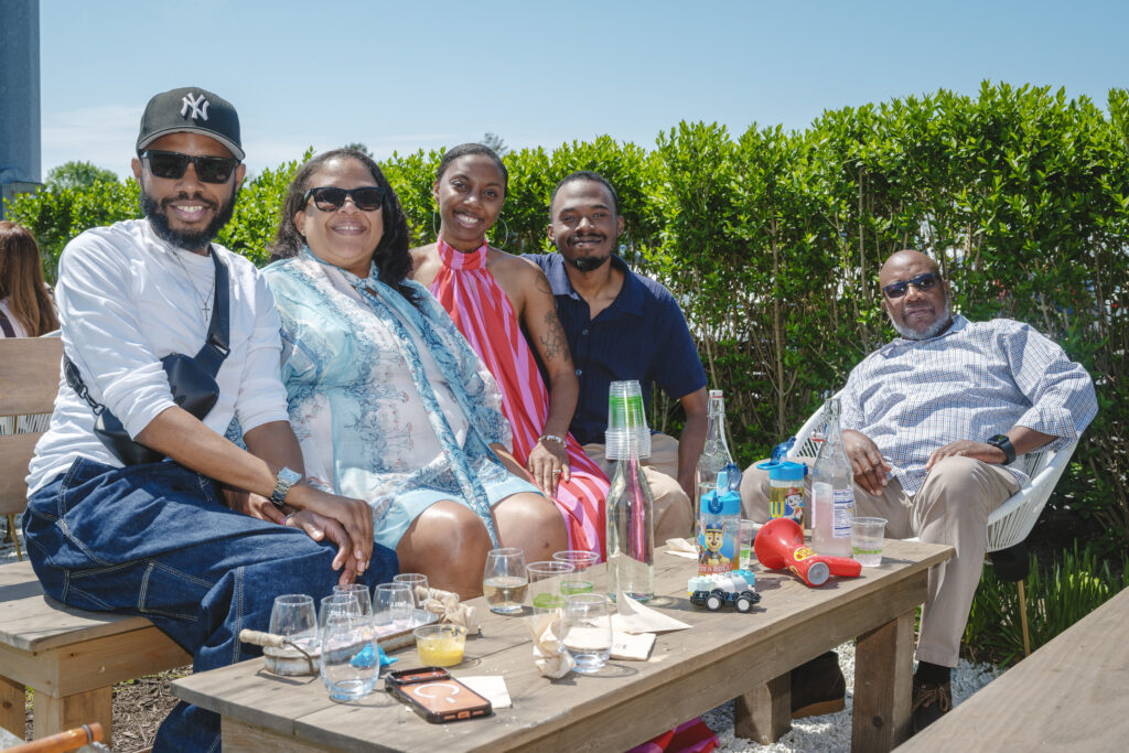 A family of five celebrates Mother's Day by posing for a photo outside on a patio at a winery.