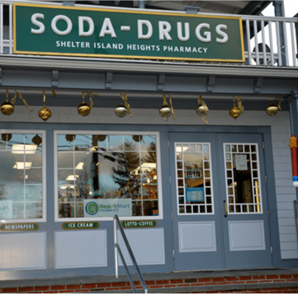 SODA-DRUGS Shelter Island Heights Pharmacy, with "NEWSPAPERS", "ICE CREAM", and "LOTTO-COFFEE" signs.