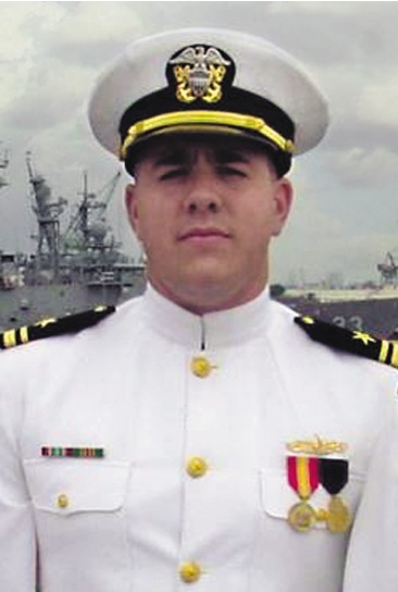 A man in a U.S. Navy uniform with medals and ribbons.